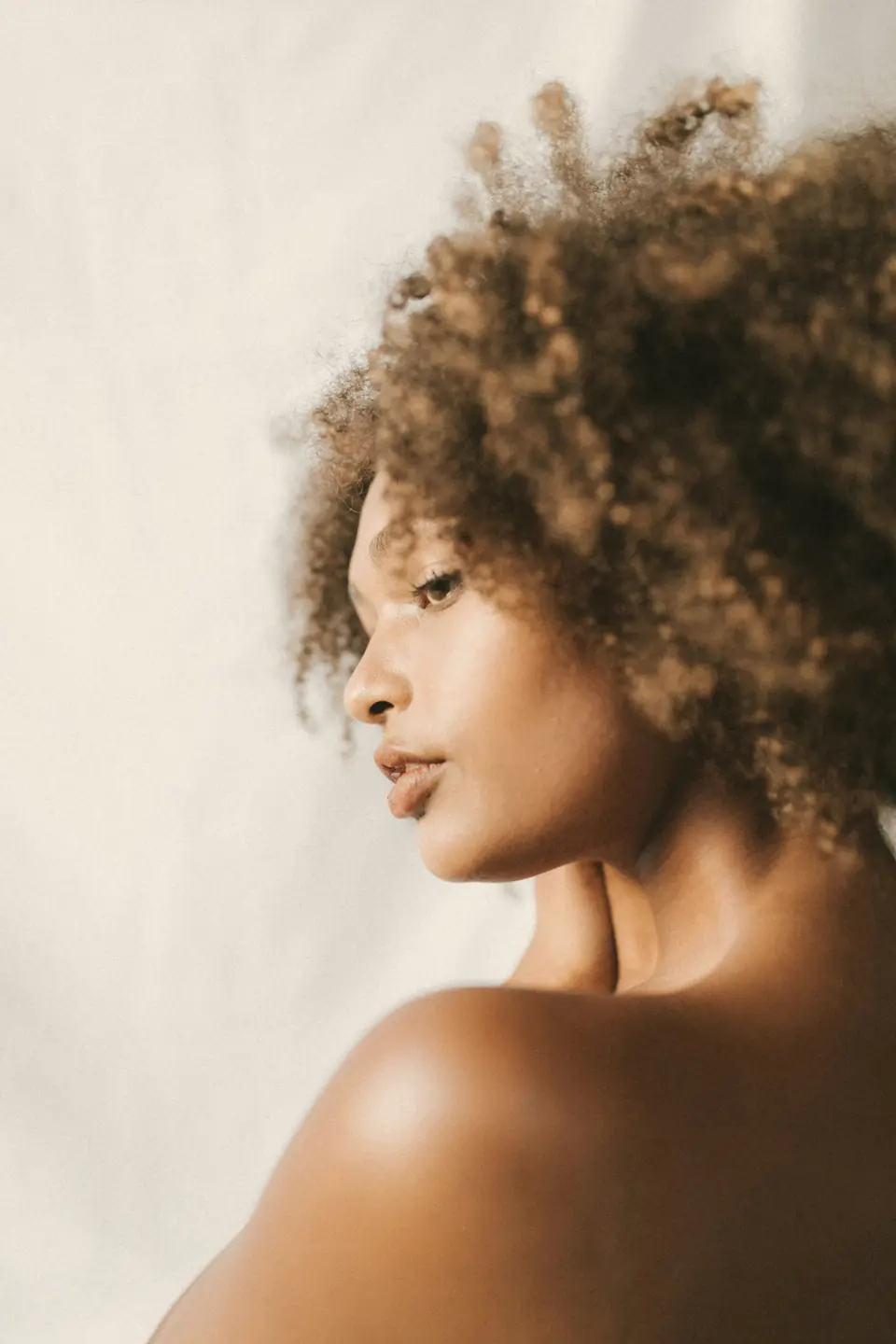 Mulher de perfil com cabelo crespo natural e volumoso