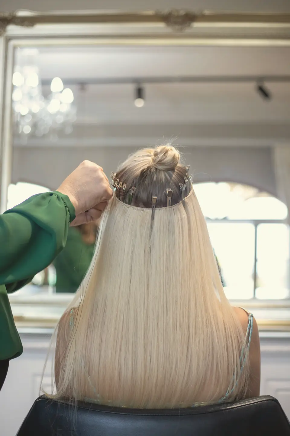 Profissional aplicando alongamento em um cabelo longo, liso e loiro
